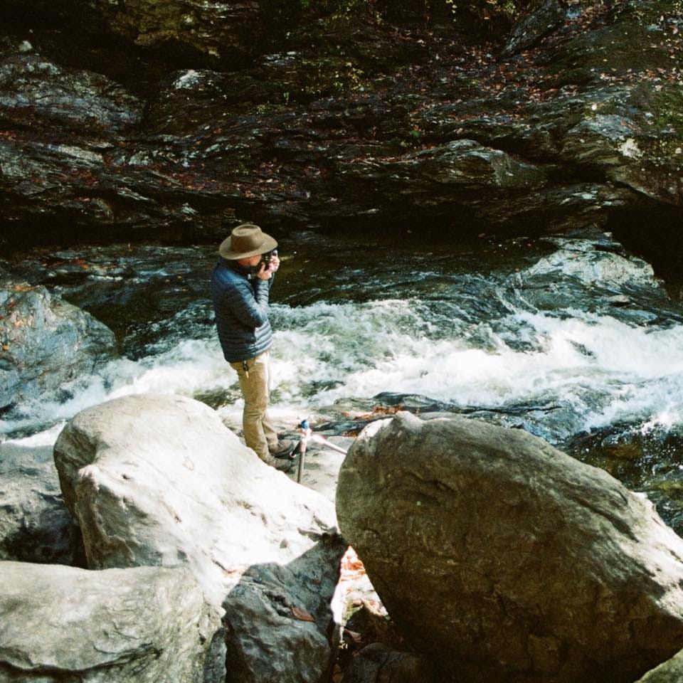 Austin Wheeler taking photos by stream in vermont